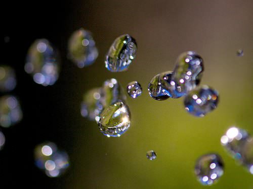 A shot of a jet of water from a hose; fast shutter speed to capture a crisp image of moving water drops.