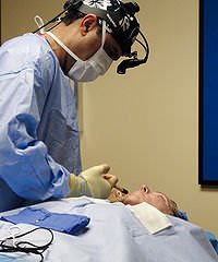 A surgeon performing a facelift procedure