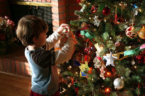 A kid decorating a Christmas tree