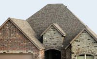A brick house with shingles used for roofing.