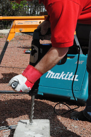 Rotary hammer drilling through hard concrete.